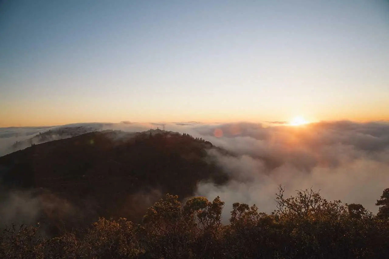 A golden sunrise over mist-covered hills