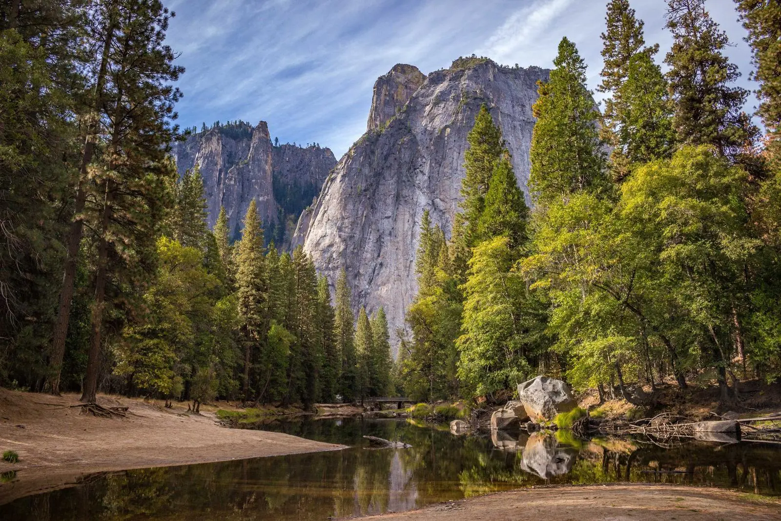 A still river reflecting mountains and forest in the valley
